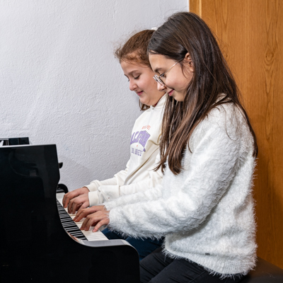 zwei Kinder am Klavier